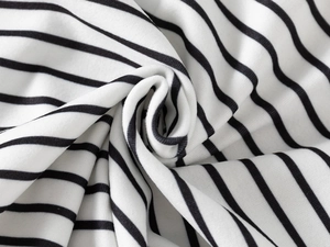 Detailed close-up of soft black and white striped knit fabric with spiral fold texture