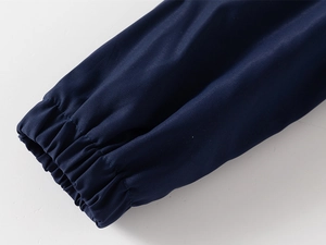 Détail de la veste enfant bleu marine montrant les poignets élastiques coupe-vent