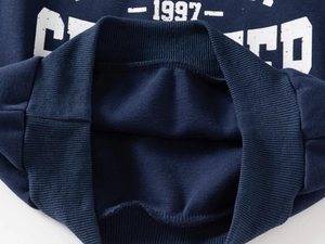 Detailed view of navy blue sweatshirt neckline with 1997 vintage print and ribbed collar