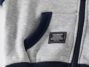 Detail of gray toddler hoodie with navy trim zipper and woven patch on the pocket