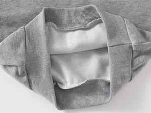 Detail of gray hoodie showing soft white fleece lining and ribbed cuff craftsmanship