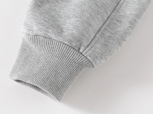 Gros plan détaillé des poignets côtelés gris clair sur un pantalon enfant épais