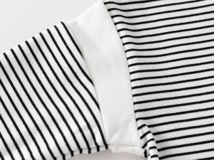Macro detail of black and white striped fabric with premium stitching on the cuff