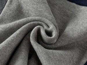 Detailed macro view of soft gray knitted fabric texture and fine ribbed neckline finish