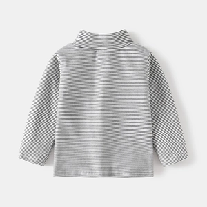 Detailed view of the soft cotton fabric and neat stitching on kids' striped turtleneck shirt