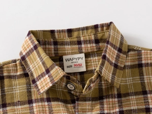 Detailed view of yellow and brown plaid flannel shirt collar with soft brushed texture