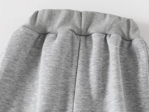 Détail du pantalon en maille gris pour enfant avec taille élastique côtelée et coton doux