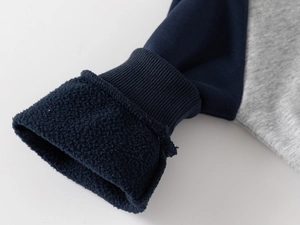 Detail of ribbed cuffs and warm fleece lining on a contrast raglan sleeve hoodie for boys