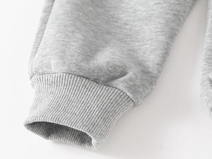Detailed close-up of thick grey ribbed cuffs and warm brushed fleece lining on boys tracksuit