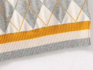 Detailed knit texture of boys' argyle sweater with ribbed hem and yellow striped accents