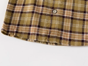 Macro detail of plaid cotton shirt fabric with decorative metallic button for boys