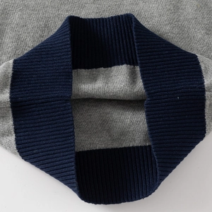 Gray knitted sweater with dark blue ribbed cuffs for boys, close-up of textured knitwear
