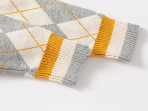 Detail of ribbed cuffs and argyle knit pattern on the thick children's winter sweater