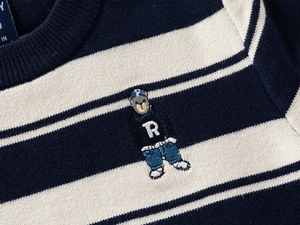 Detail shot of navy and cream striped knit sweater featuring a premium bear embroidery