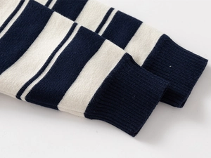 Detailed macro view of striped knit sweater cuffs with premium ribbed finish and texture