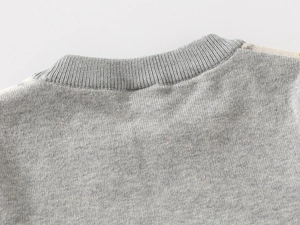 Detailed close-up of the grey ribbed knit crew neck and flat-stitch texture on a boy sweater