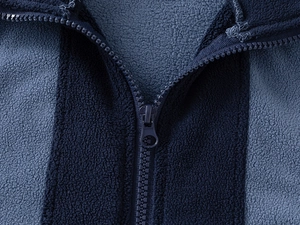 Macro detail of high-quality zipper and fleece texture on toddler color-block jacket