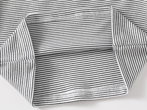 Detailed macro view of the double-stitched hem on the striped turtleneck thermal top