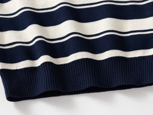 Close-up of ribbed hem detail on children's navy and beige striped knit sweater
