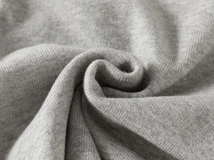 Close-up of grey knit sweater fabric showing soft fleece lining and fine ribbed texture