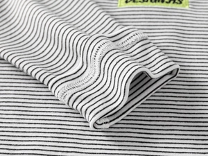 Detail of children's striped thermal top showing double-stitched cuffs and neon label