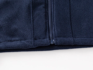 Detail shot of navy polar fleece jacket showing smooth zipper and stitched hem