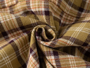Close-up of mustard yellow plaid flannel fabric with soft brushed texture for kids shirt