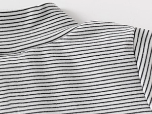 Close-up of the high-neck collar and stitching on the black and white striped knit shirt