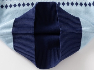 Detailed macro view of high-quality light blue knitted fabric with dark blue argyle pattern