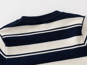 Detailed close-up of ribbed crew neck and navy striped pattern on knit sweater