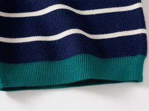 Detail of blue and white striped knit sweater with green ribbed hem and soft texture
