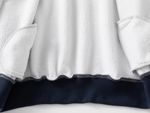 Detail of soft white sherpa lining and navy ribbed hem on kids' varsity jacket