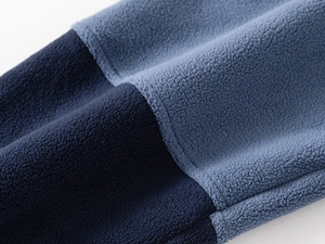 Detailed view of thick polar fleece fabric with blue color blocking and fine stitching