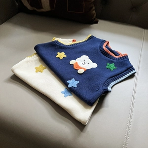 Detail of knit vests featuring colorful star patches and bear embroidery on the front