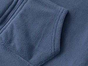 Détail du tissu polaire bleu marine avec fermeture éclair en résine et coutures de poche