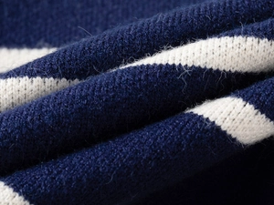 Macro shot showing soft blue and white striped knitted wool texture of the kids sweater