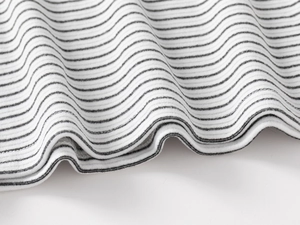 Close-up of black and white striped ribbed knit fabric with neat hem stitching detail