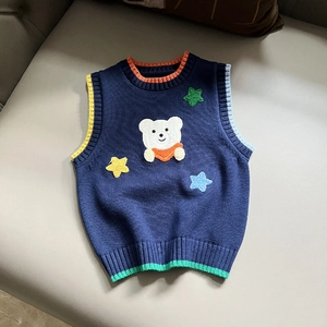 Detail of knit vest showing striped ribbed collar and bear patch with star embroidery