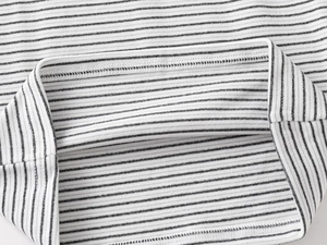 Close-up of fine ribbed texture and neat stitching on black and white striped thermal shirt