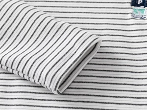 Close-up of black and white striped sleeve with ribbed cuffs and letter P embroidery