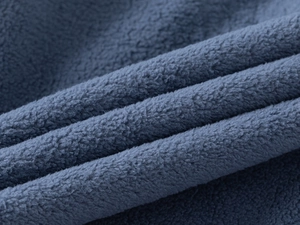 Gros plan sur la texture du tissu polaire bleu marine montrant douceur et épaisseur