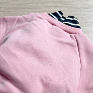 Detail of pink fleece sweatshirt with black and white striped collar for kids