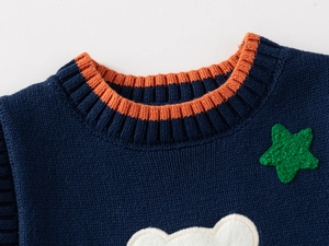 Detail of knitted V-neckline with colorful ribbing and cute cartoon bear embroidery
