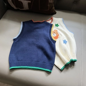 Detail of knit vests with colorful ribbed edges and cute cartoon bear embroidery