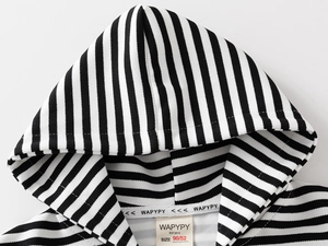 Détail du sweat à capuche rayé noir et blanc avec texture tricotée et étiquette tissée