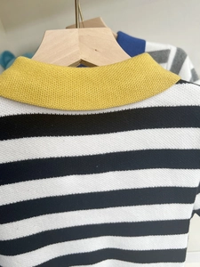 Detailed view of striped knit sweater with contrasting bright yellow polo collar