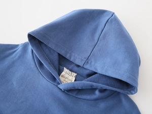 Detail of blue cotton hoodie collar showing soft french terry fabric and size 90 neck label