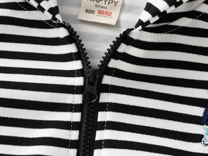 Détail de l'étiquette et de la fermeture éclair noire sur un sweat à capuche rayé