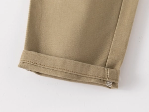 Close-up of boys' khaki casual trousers featuring cuffed hem and twill fabric texture
