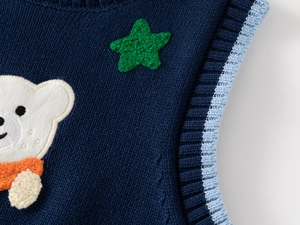 Detail of blue knit vest featuring ribbed neckline and cute bear embroidery for kids